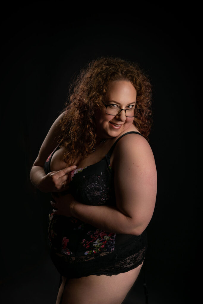 A woman with curly hair wearing glasses and a floral dress. Image by Shayna Hardy Photography Maryland.